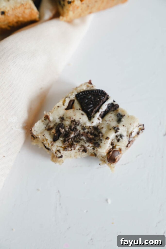Close-up of a stack of Oreo Blondies, revealing the soft interior and generous Oreo and chocolate chip filling.