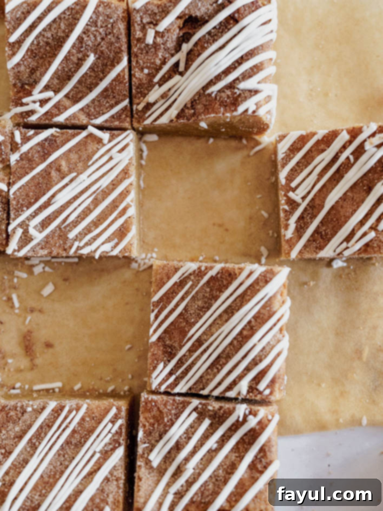 Close-up of freshly baked Cinnamon Roll Blondies with visible cinnamon swirl and cream cheese icing.
