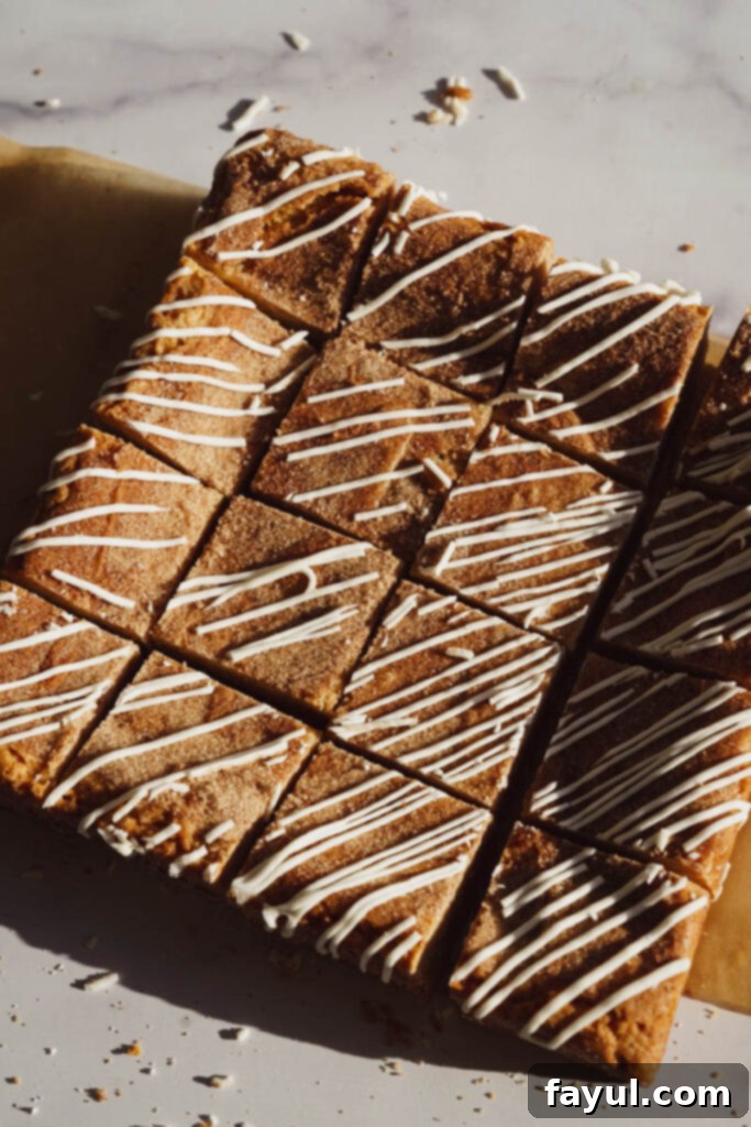 A cutting board with several squares of Cinnamon Roll Blondies.