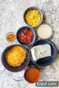 Chili cheese dip recipe ingredients in bowls on a white counter.