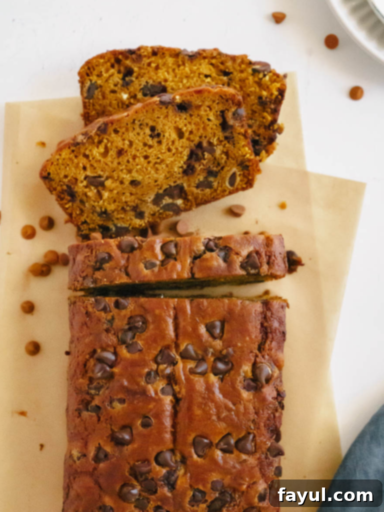 A perfectly sliced loaf of Pumpkin Chocolate Chip Bread with chocolate chips visible in the moist crumb, ready to be enjoyed.
