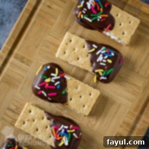 Overhead shot of s'mores bites in a row on a wooden cutting board.