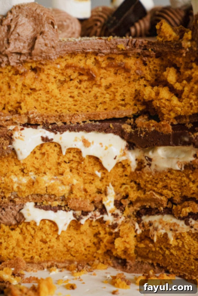 A beautifully frosted Pumpkin S'mores Cake on a cake stand.