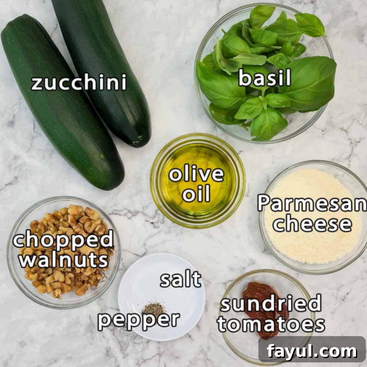 Overhead shot of ingredients - zucchini, basil, olive oil, parmesan cheese, sundried tomatoes, chopped walnuts, salt, and pepper.