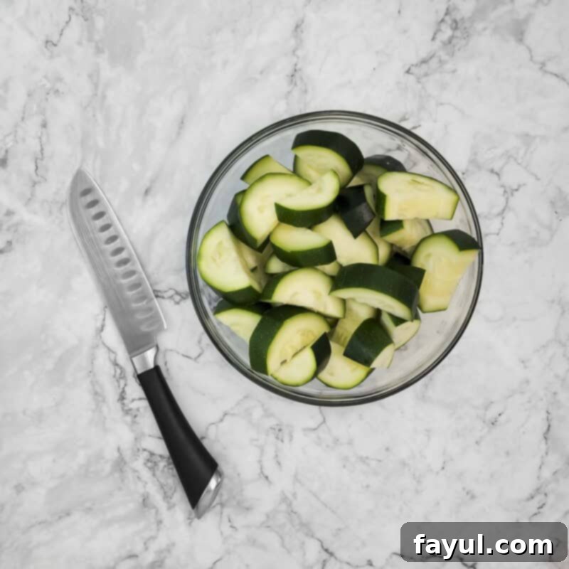 Overhead view of process shot 1 - slice the zucchini into chunks.