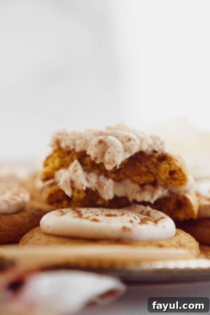 Creamy Pumpkin Spice Sugar Cookie 10 A close-up of a beautifully frosted pumpkin sugar cookie on a white napkin
