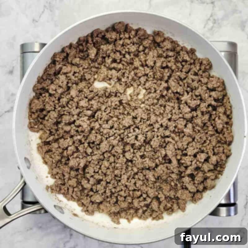 Overhead view of process shot 2 - break up the beef into crumbles and cook until browned, about 5-7 minutes. Drain the excess grease.