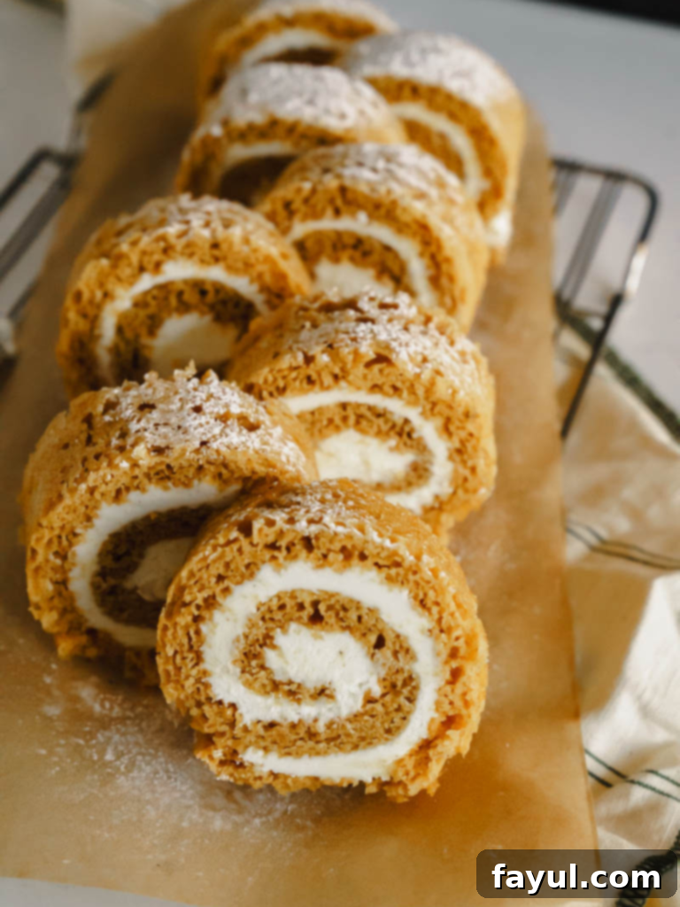 Beautifully sliced Pumpkin Roll with cream cheese filling, dusted with powdered sugar