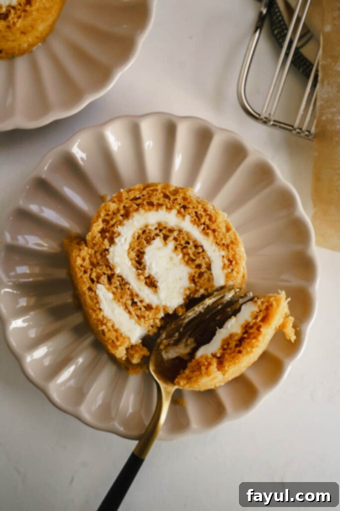 Top-down view of a whole Pumpkin Roll, beautifully dusted with powdered sugar