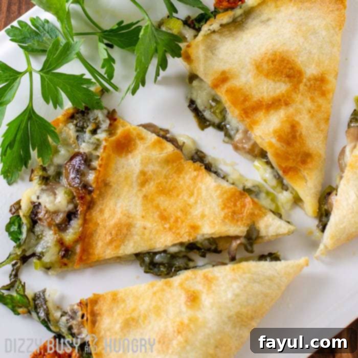 Overhead shot of baked spinach mushroom quesadillas sliced into pieces on a white plate with herbs on the side, a perfect example of a budget-friendly and delicious meal for family meal planning.