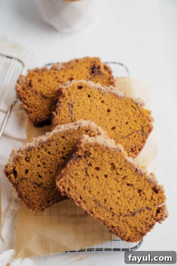 Unbaked pumpkin bread batter layered with cinnamon swirl and streusel topping in a loaf pan