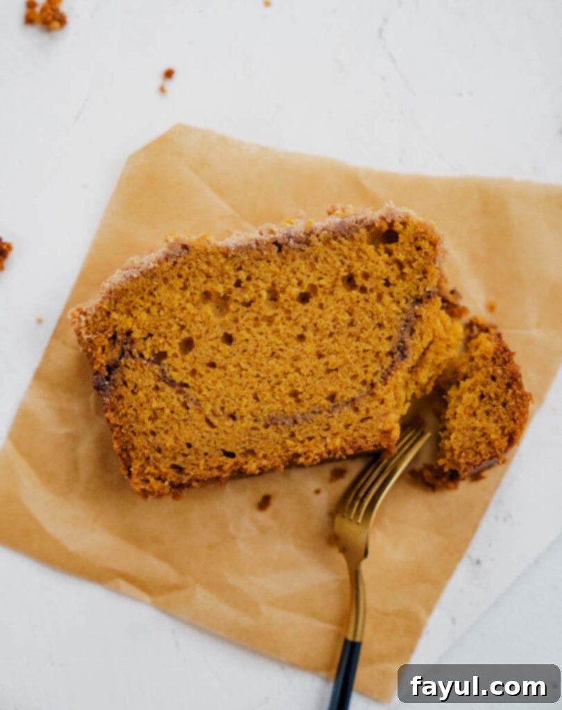 Freshly baked pumpkin bread with streusel on a wooden cutting board