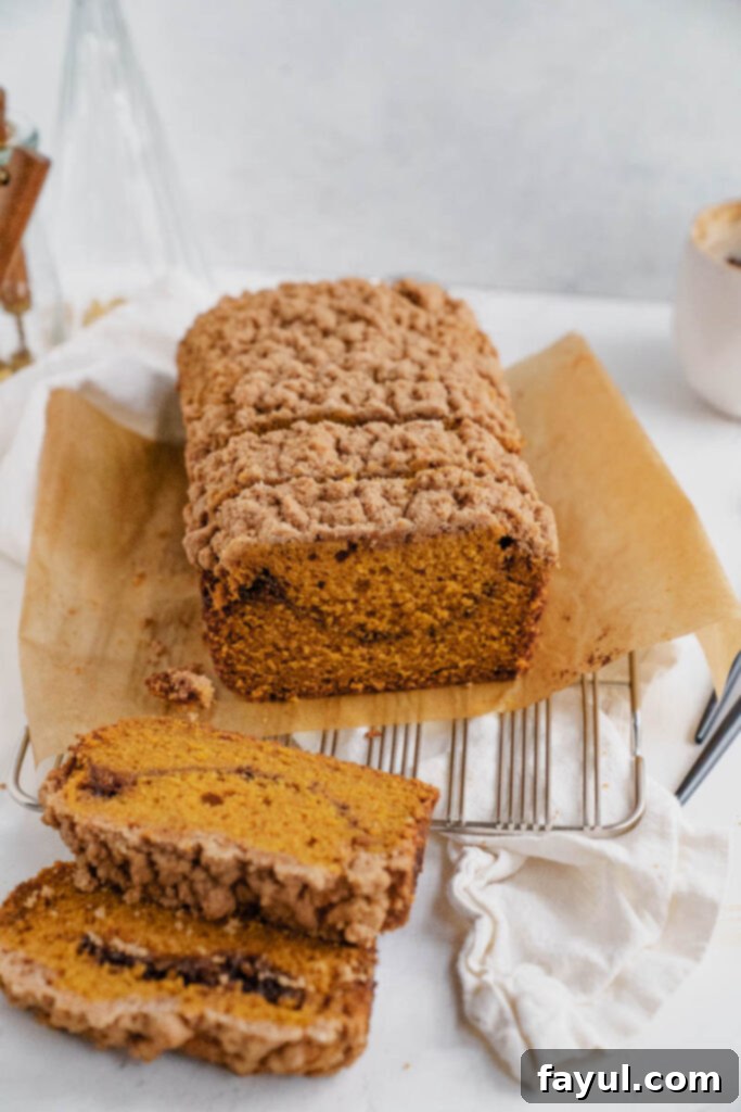 Close-up of a slice of pumpkin bread with streusel being served