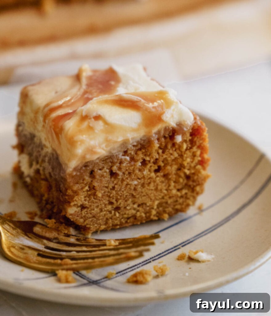 Homemade caramel sauce being drizzled generously over a frosted gingerbread cake.
