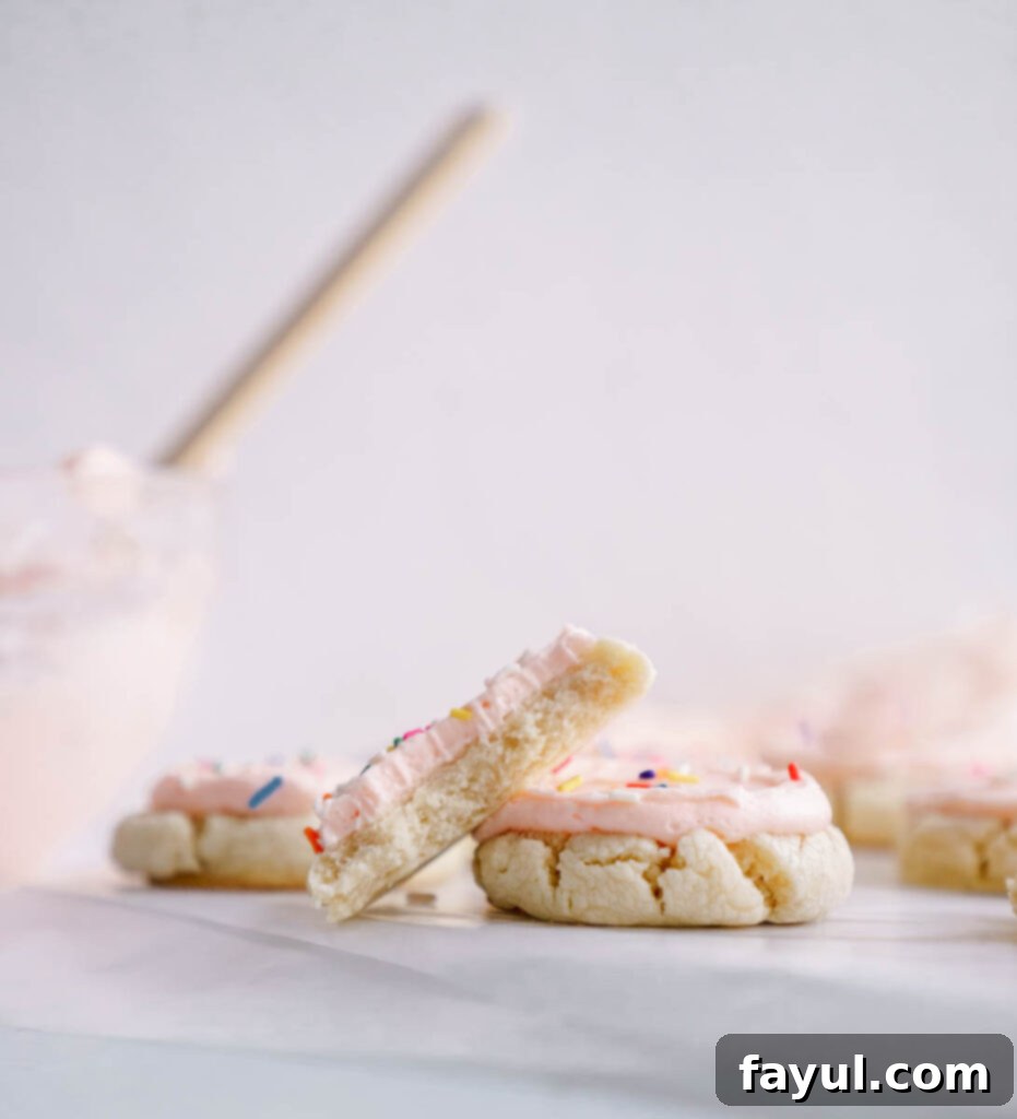 Two Lofthouse sugar cookies with pink frosting, ready to be eaten