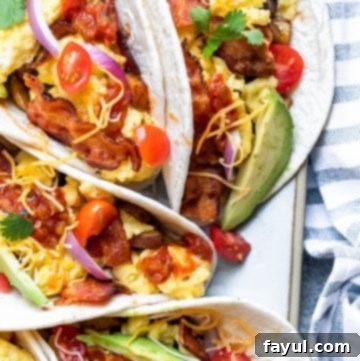 Overhead shot of perfectly arranged breakfast tacos on a white platter, ready to be served.
