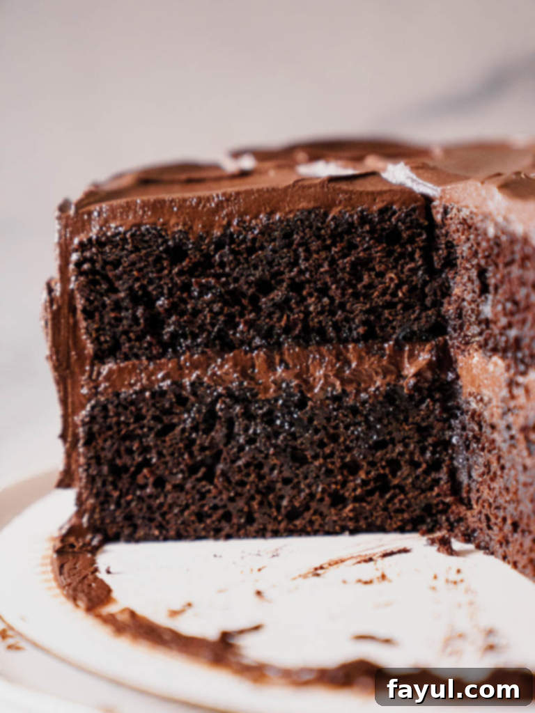 Two slices of Portillo's Chocolate Cake on plates, showing the moist layers and fudgy frosting.