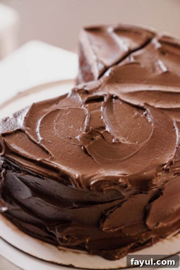 Close-up of a frosted Portillo's Chocolate Cake slice, showcasing the texture.