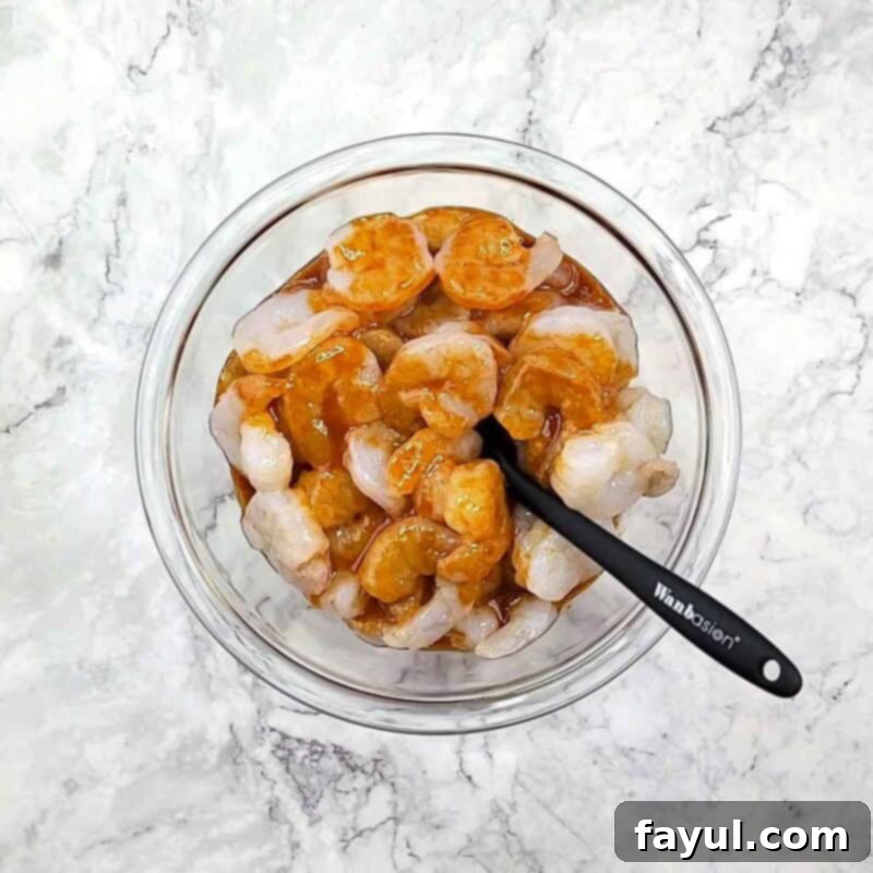 Overhead view of process shot 2 - place the shrimp in a large bowl, add the marinade, and toss to coat.