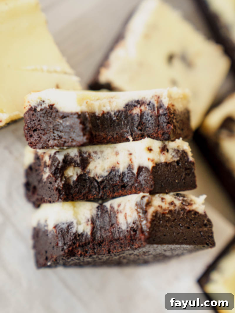 Delicious Fudgy Cheesecake Brownies cut into perfect squares, showcasing the distinct layers and swirls.