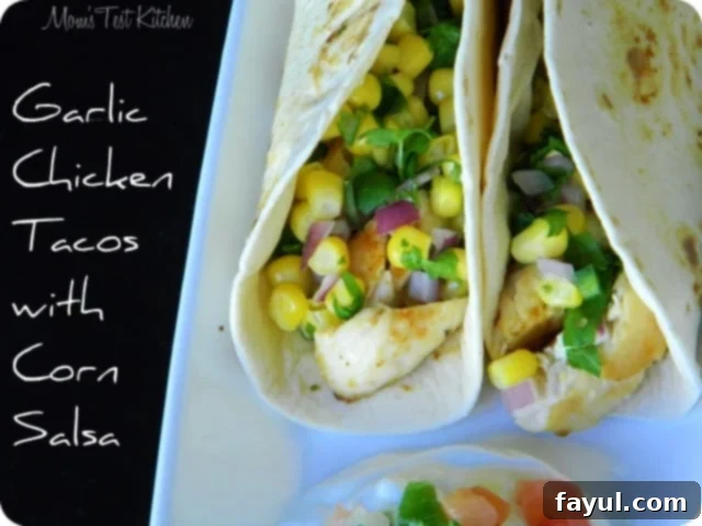 Two soft tacos filled with grilled chicken, corn, red onion, and cilantro with the overlaying text Garlic Chicken Tacos With Corn Salsa.