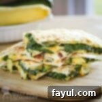 Overhead shot of three halves of spinach quesadillas stacked on a wooden cutting board with a bowl with zucchinis in the background.