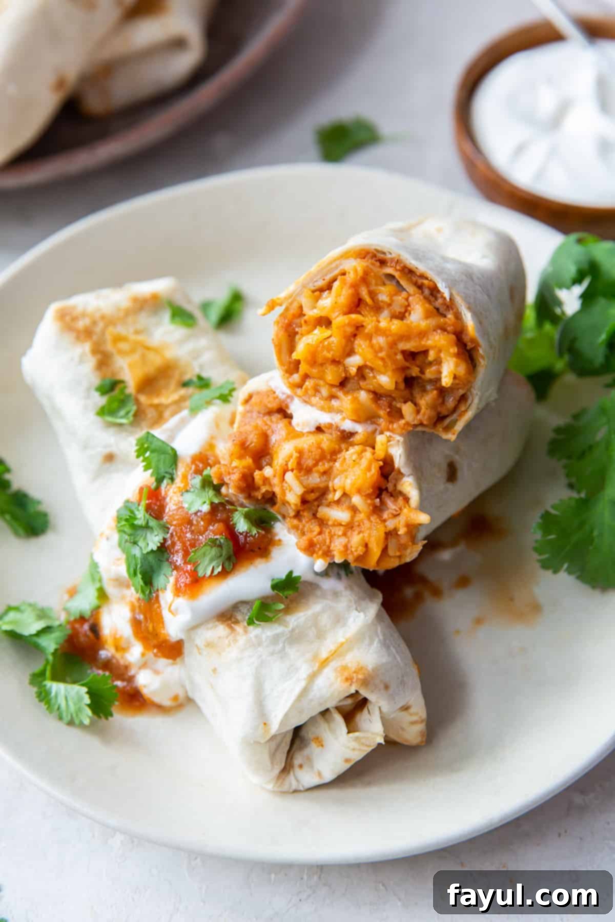 Burritos stuffed with beans, Mexican rice, and melted cheese and topped with parsley.