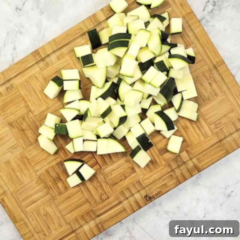 Overhead view of process shot 1 - chop the zucchini into bite sized pieces, ensuring they are chunky.