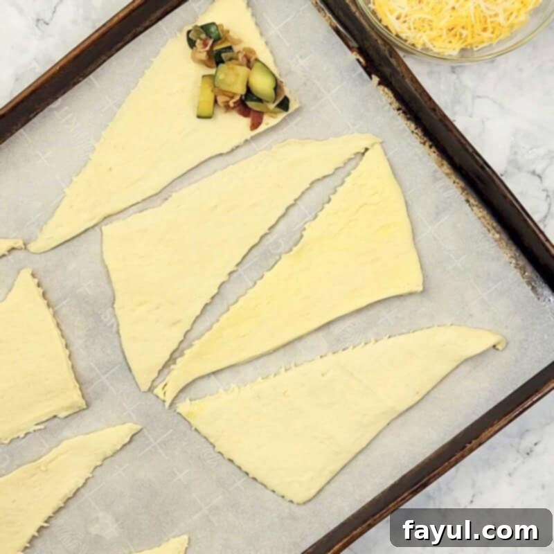 Overhead view of process shot 4 - separate each crescent roll triangle and place a spoonful of filling on the wider end.