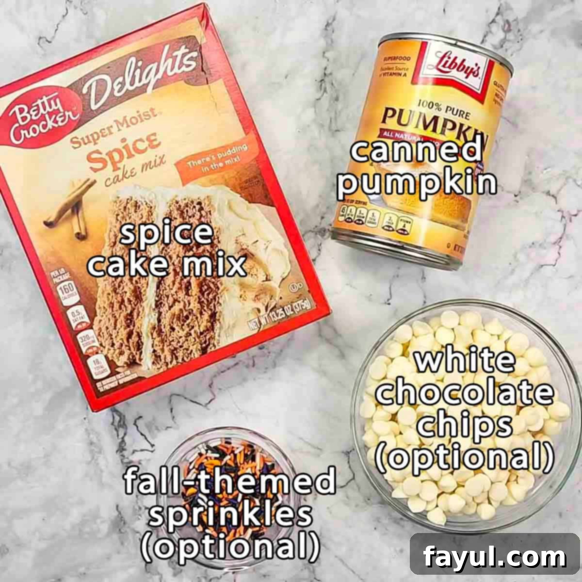 Overhead shot of ingredients - spice cake mix, canned pumpkin, white chocolate chips, and fall themed sprinkles.