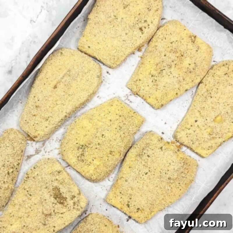 Overhead view of process shot 4 - place the breadcrumbs in a wide dish and dip each slice of eggplant in the breadcrumbs to coat.