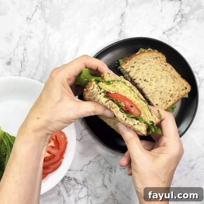 Overhead view of process shot 7 - serve and enjoy! Finished Eggplant Milanese sandwich with fresh lettuce and tomato.