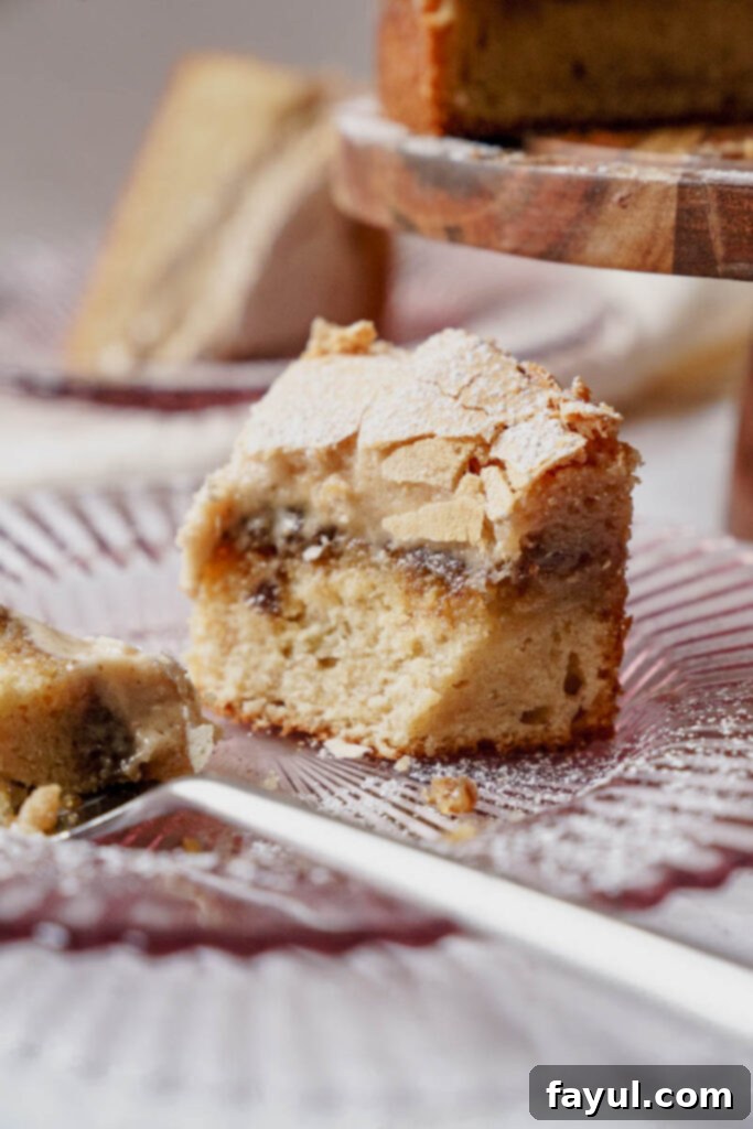 Close-up of a slice of Cinnamon Roll Gooey Butter Cake showing the gooey top layer