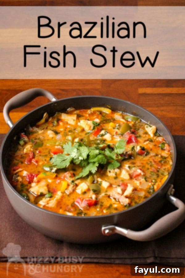 Side view of fish stew in brown pot on a brown placemat.