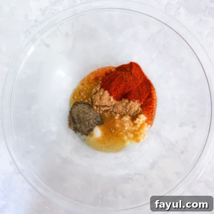 Overhead shot of clear bowl with ingredients combined to make marinade.