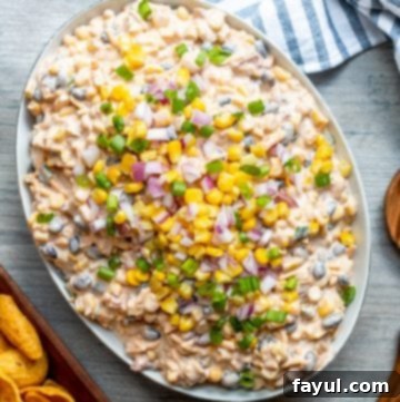 Overhead shot of a large white bowl filled with vibrant Fiesta Corn Dip, ready to be served.