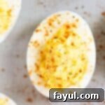 Close up of a classic deviled egg with paprika.