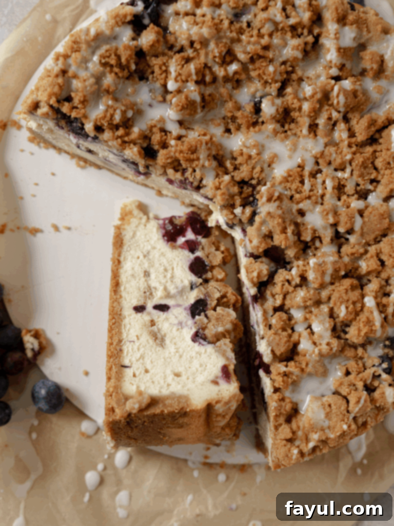 Delectable Blueberry Muffin Cheesecake with a generous streusel topping, showcasing fresh blueberries and a golden crust.