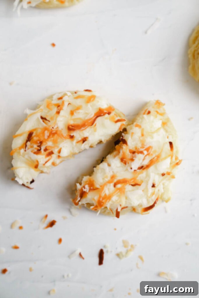 A stack of frosted coconut caramel sugar cookies with a bite taken out
