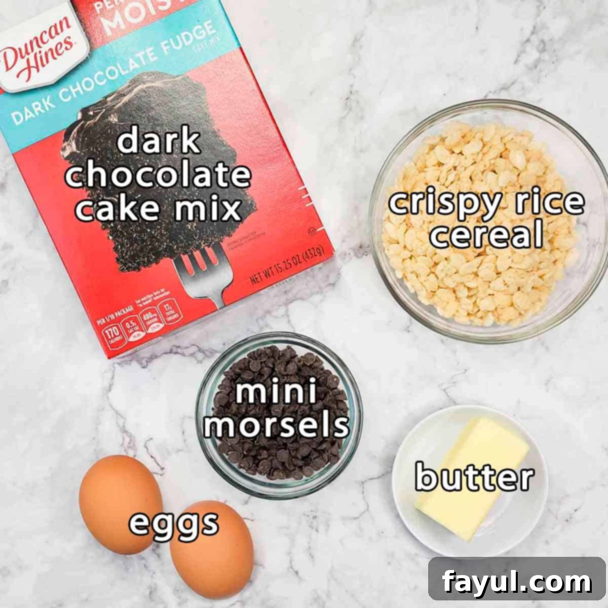 Overhead shot of ingredients - dark chocolate cake mix, crispy rice cereal, mini morsels, butter, and eggs.