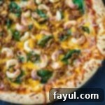 Close up shot of part of a whole basil pizza on a pan.