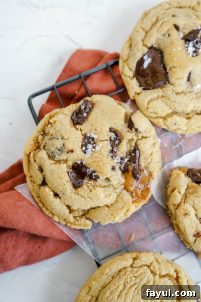 Close-up of cookie dough being scooped, with a soft caramel pressed into the center