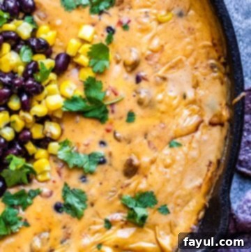 Overhead shot of queso in a black skillet on blue counter.