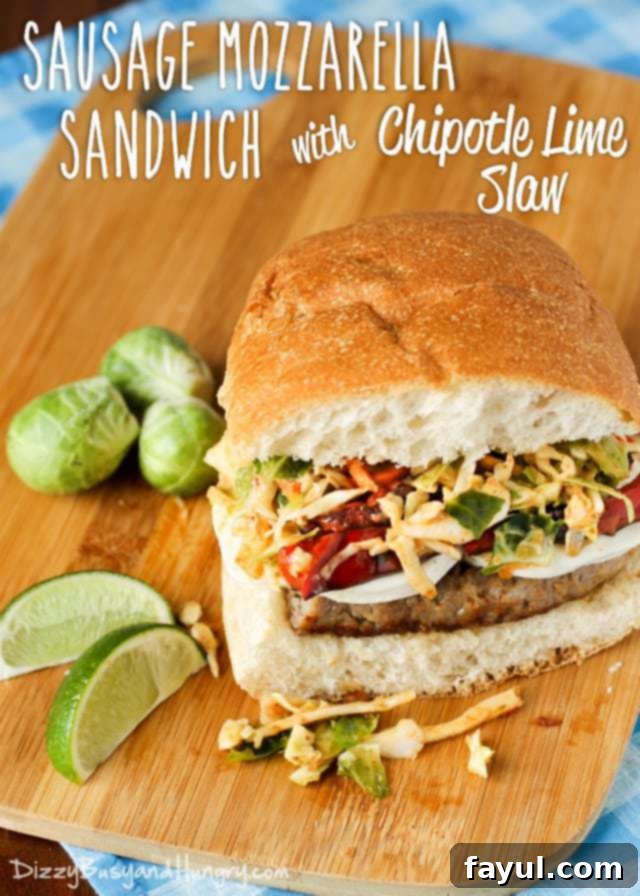 Close up shot of sausage mozzarella sandwich with chipotle lime slaw with sliced lime and Brussel sprouts on the side.