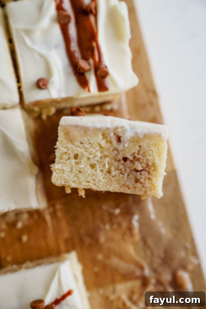 Slice of Cinnamon Roll Poke Cake with a fork.