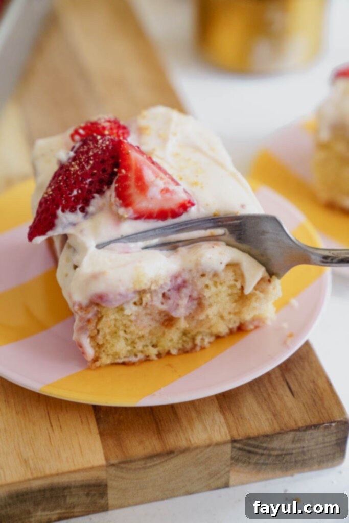 Top view of a whole Strawberry Poke Cake, garnished with fresh berries