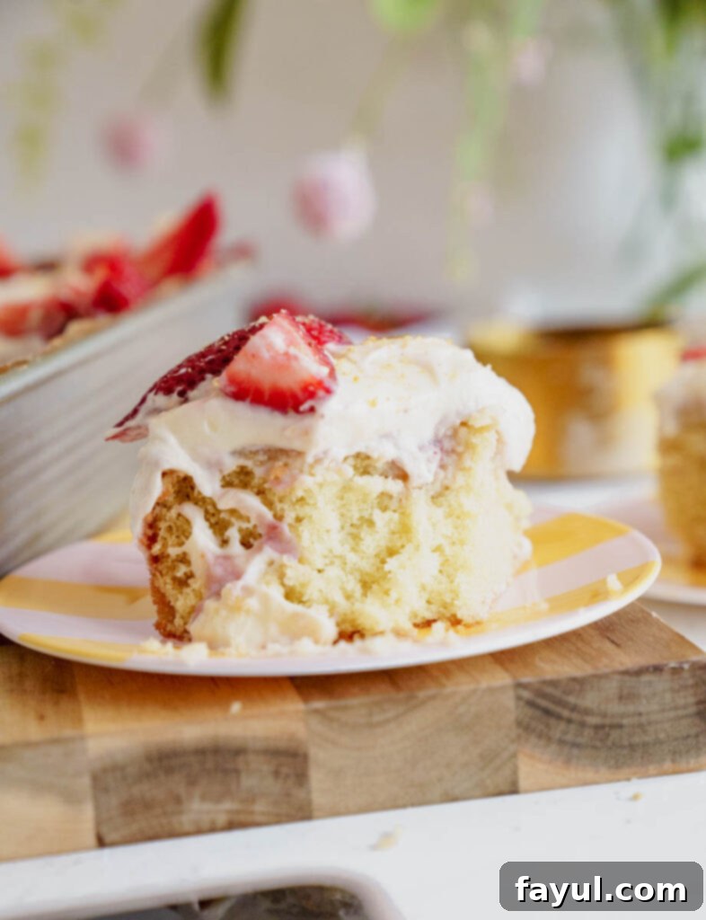 Pouring strawberry sauce over the poked holes of the cake