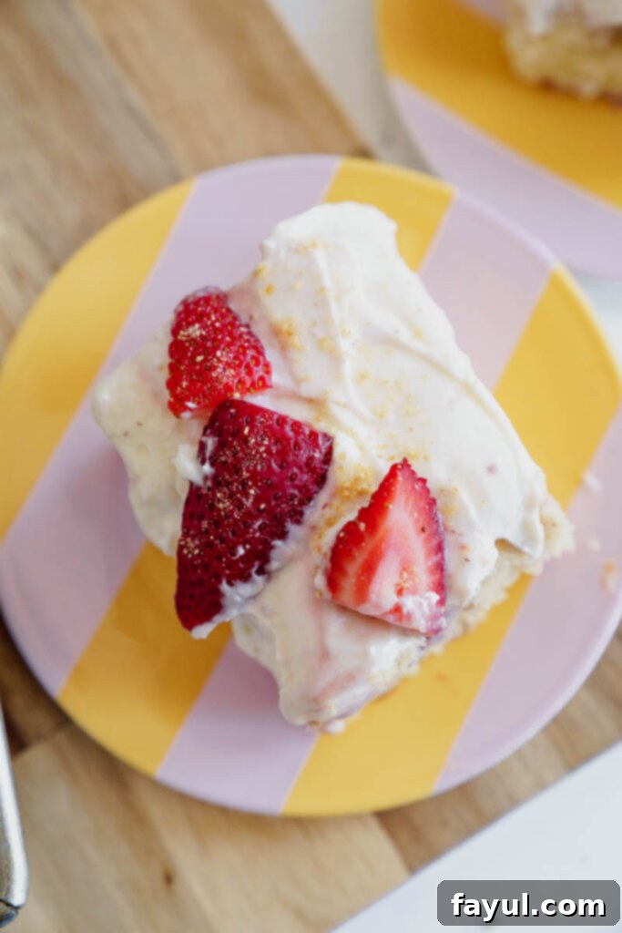 Spreading creamy frosting over a Strawberry Poke Cake