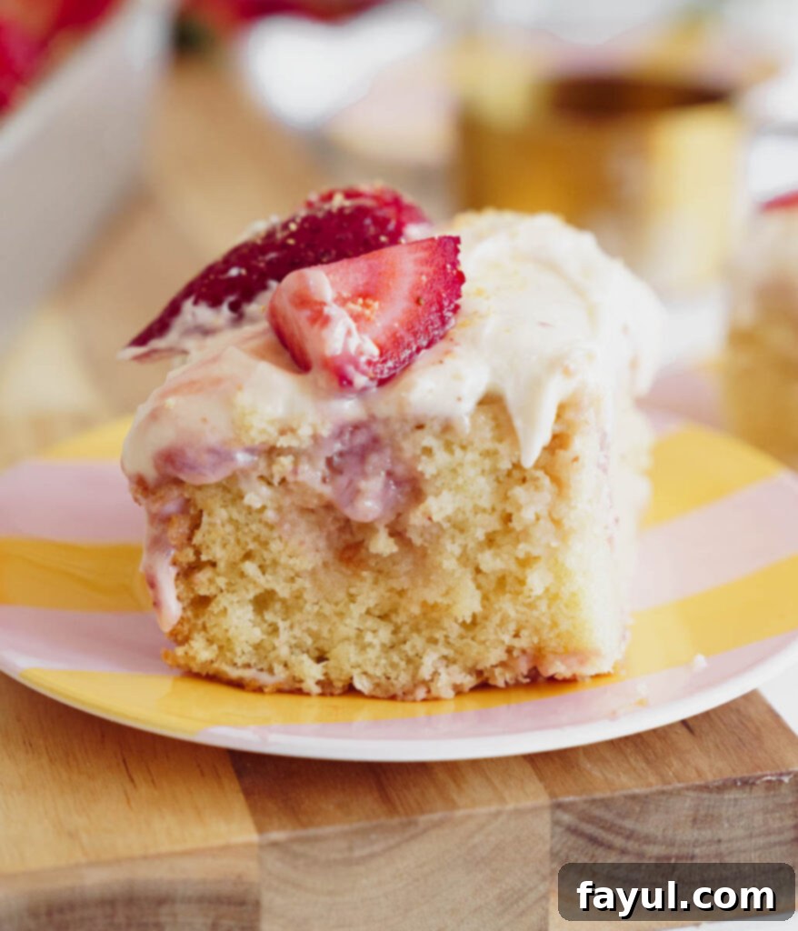 A large slice of Strawberry Poke Cake on a white plate