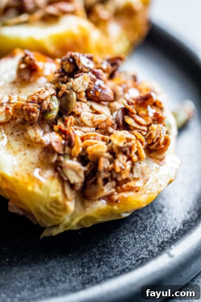 Close-up shot of an air-fried apple half with a golden-brown oat topping on a black plate, ready to be served.